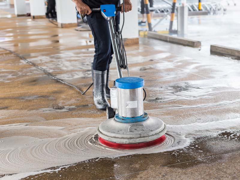Worker cleaning the floor using phosphated phenol ethoxylates manufactured in the UK by Lakeland.